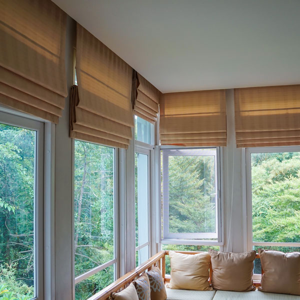 tan roller shades on windows in woods
