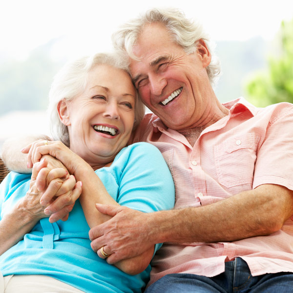 Senior couple smiling after dental restorations & prosthodontics treatment in Santa Barbara, CA