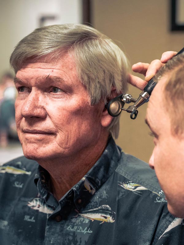 doctor looking into man's ear