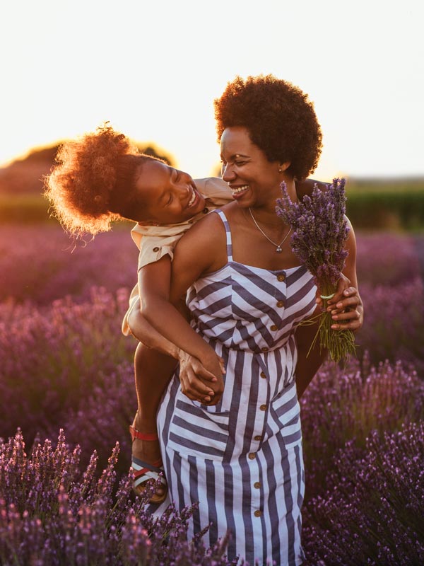 woman and daughter smiling in field of lavender