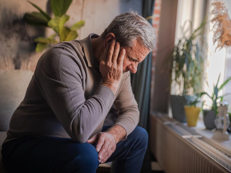 man holding ear in pain
